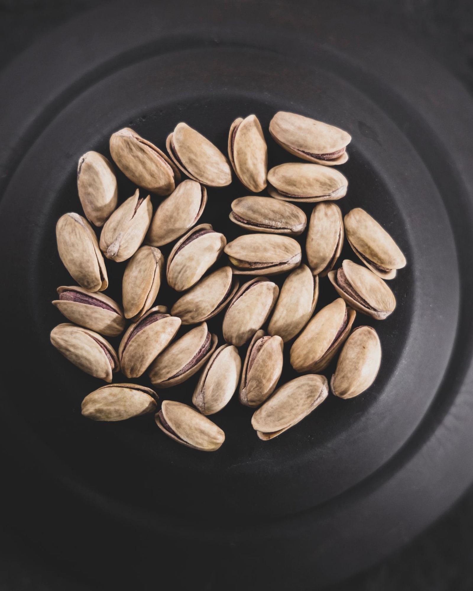 Pistachios in a black bowl