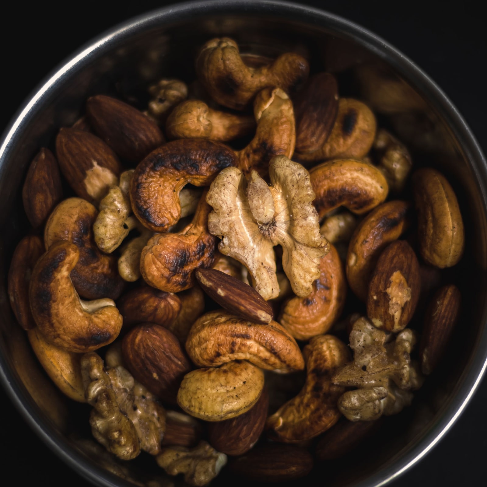 Roasted mixed nuts in a dark bowl